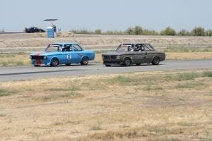 A pair of vintage BMW 2002s dueling it out on the racetrack